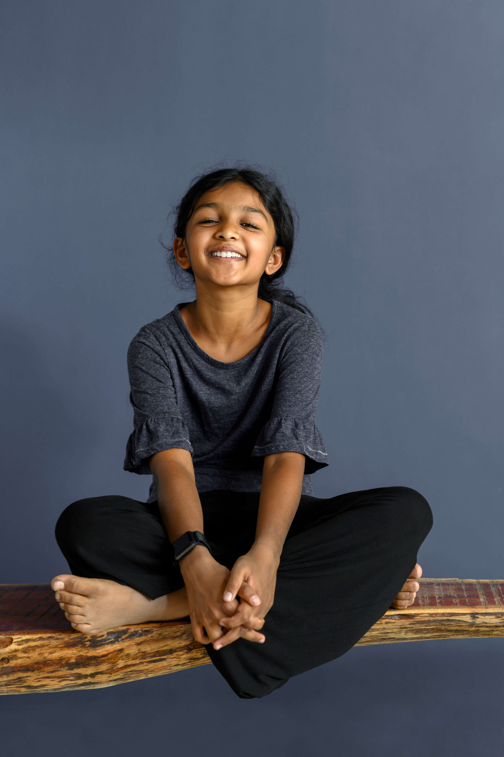 Smiling young Indian girl after meditation in yoga pose.