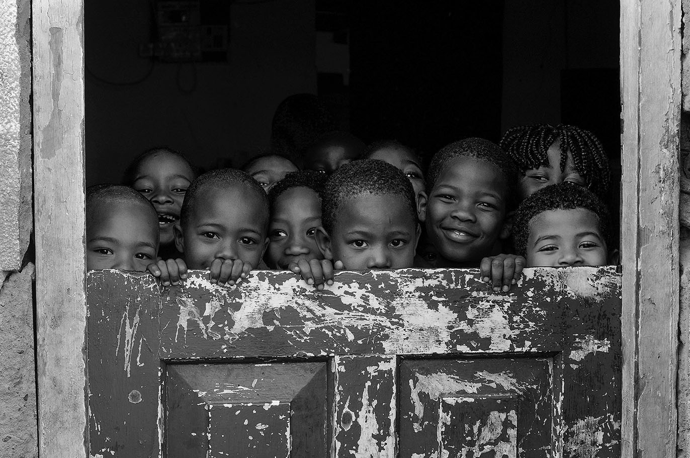 African children peeping over a door