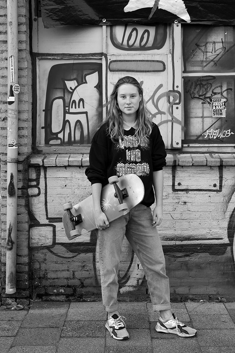 Girl and skateboard in front of a graffiti wall in the Netherlands