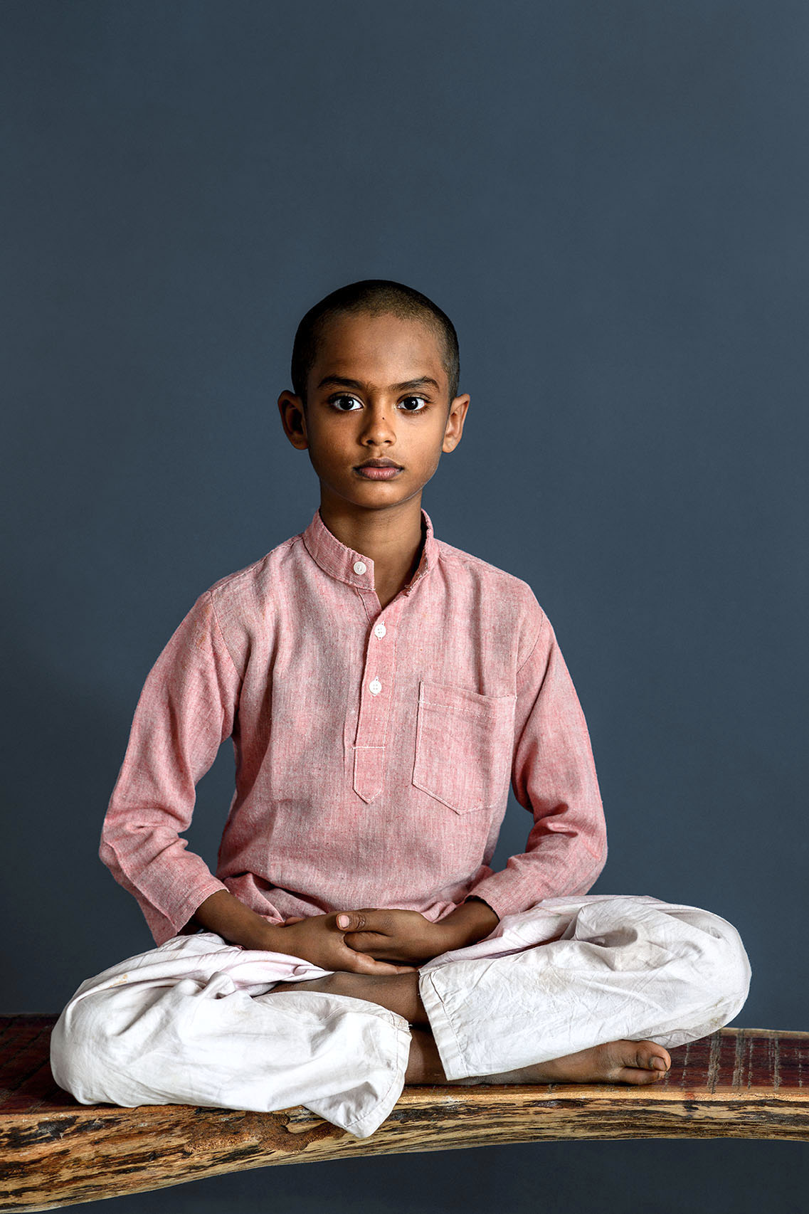 Boy in meditation pose India.