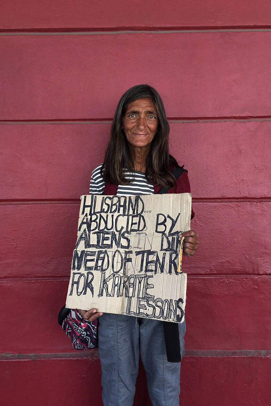 Woman on the street asking for money in humorous way.
