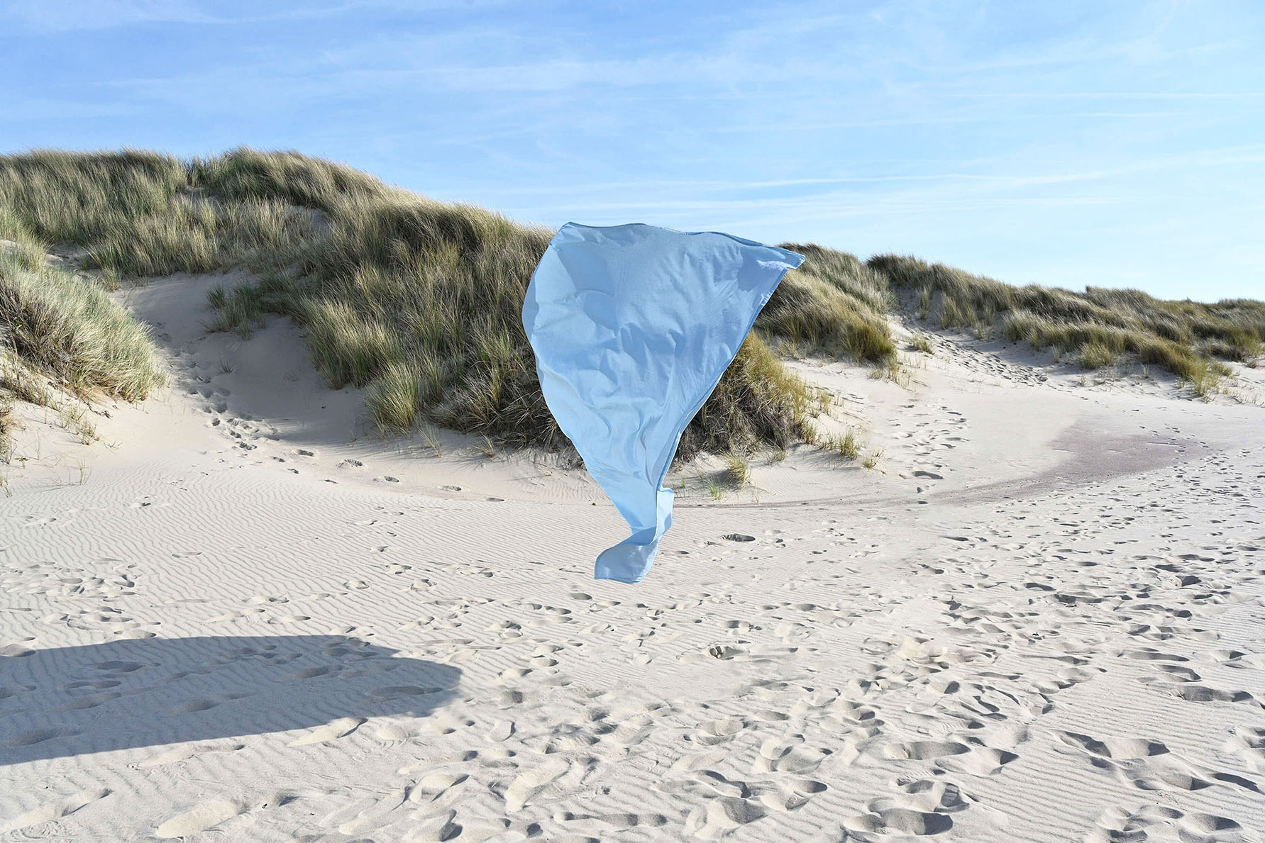 A blue bacdrop caught in the wind on a beach in Zeeland in the Netherlands